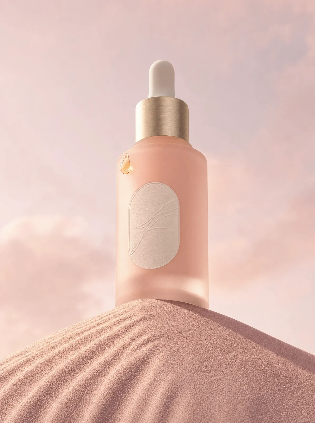 The Dew Diligence 30 ml frosted blush dropper bottle with a gold collar, standing on a rippled pink dune